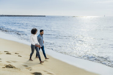 Spanien, Barcelona, Paar läuft barfuß am Strand - BOYF01280