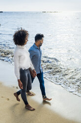 Spanien, Barcelona, Paar läuft barfuß am Strand - BOYF01281