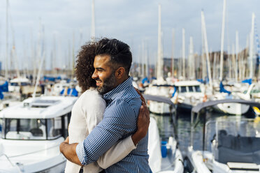 Spain, Barcelona, happy couple hugging at the marina - BOYF01292