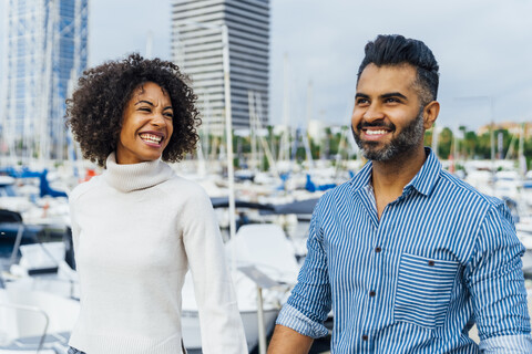 Spanien, Barcelona, glückliches Paar beim Spaziergang am Yachthafen, lizenzfreies Stockfoto
