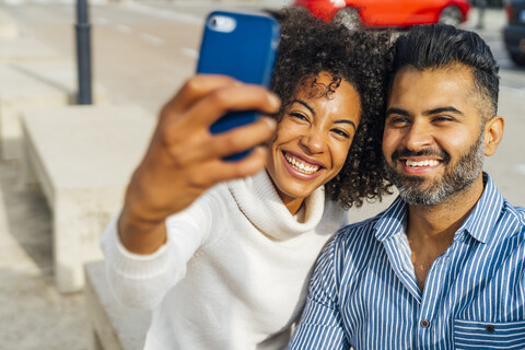 Glückliches Paar macht ein Selfie im Freien, lizenzfreies Stockfoto