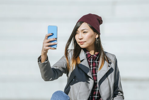 Porträt einer jungen Frau, die ein Selfie mit ihrem Smartphone macht - KIJF02208