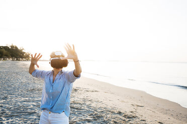 Thailand, Rayong, Frau mit Virtual-Reality-Brille am Strand - HMEF00181