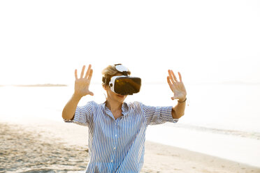 Thailand, Frau mit Virtual-Reality-Brille am Strand - HMEF00183