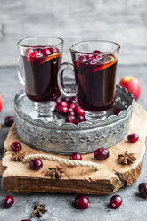 Zwei Gläser Glühwein mit Preiselbeeren, Orangenspalten und Sternanis auf dem Tablett - SARF04057