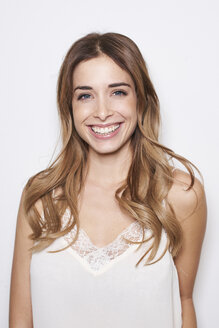 Portrait of laughing young woman wearing white top - PNEF01162