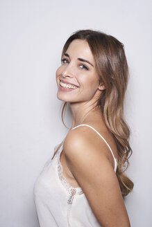 Portrait of laughing young woman wearing white top - PNEF01163