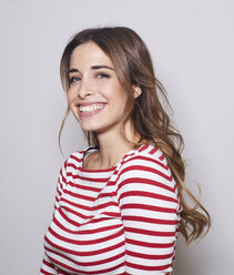 Portrait of laughing young woman wearing red-white striped shirt - PNEF01164