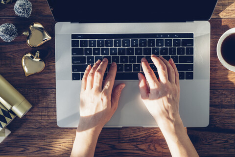 Hände einer Frau, die auf einem Laptop tippen, Ansicht von oben, lizenzfreies Stockfoto