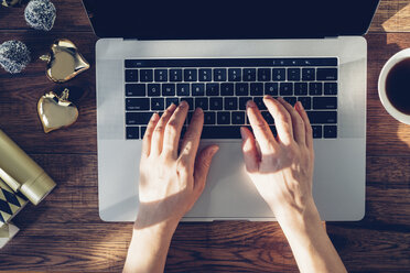 Hände einer Frau, die auf einem Laptop tippen, Ansicht von oben - MOMF00590
