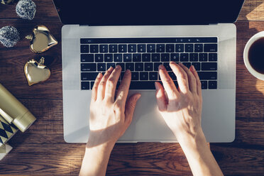 Woman's hands typing on laptop, top view - MOMF00590