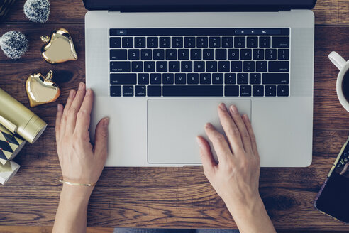 Woman's hands using laptop, top view - MOMF00592