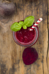 Glass of beet root smoothie garnished with basil leaves - LVF07688