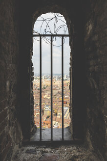 Italien, Bologna, Blick auf die Stadt durch Mauerwerk mit Metallgitter - WPEF01293