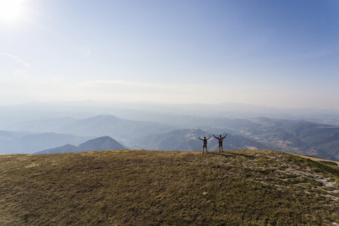 Italien, Monte Nerone, zwei Wanderer auf dem Gipfel eines Berges, die die Aussicht genießen - WPEF01295