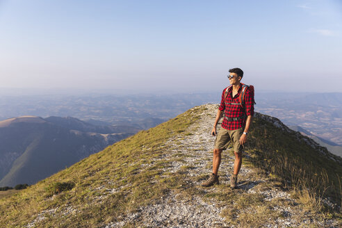 Italien, Monte Nerone, Wanderer auf dem Gipfel eines Berges mit Blick auf das Panorama - WPEF01298