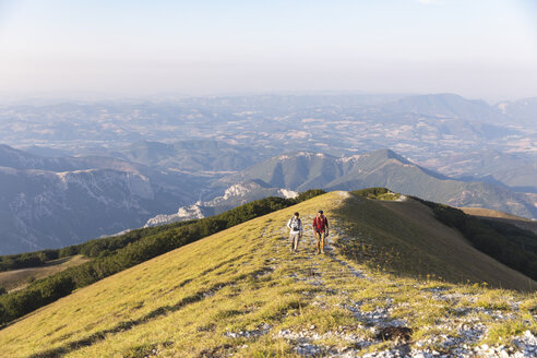 Italien, Monte Nerone, zwei Männer wandern im Sommer auf dem Gipfel eines Berges - WPEF01303