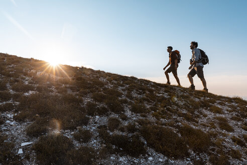 Italien, Monte Nerone, zwei Männer wandern in den Bergen bei Sonnenuntergang - WPEF01307