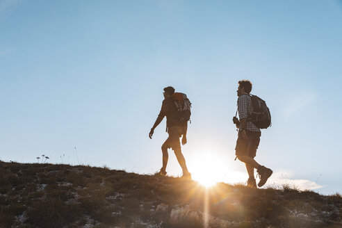 Italien, Monte Nerone, zwei Männer wandern in den Bergen bei Sonnenuntergang - WPEF01308