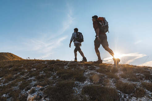 Italy, Monte Nerone, two men hiking in mountains at sunset - WPEF01310