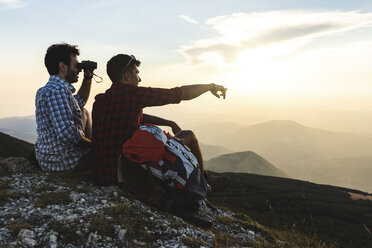 Italien, Monte Nerone, zwei Wanderer auf dem Gipfel eines Berges, die die Aussicht bei Sonnenuntergang genießen - WPEF01314