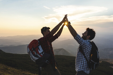 Italy, Monte Nerone, two happy and successful hikers in the mountains at sunset stock photo