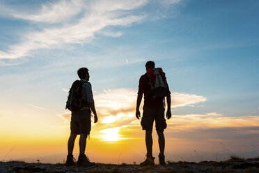 Italien, Monte Nerone, zwei Wanderer genießen die Aussicht auf dem Gipfel eines Berges bei Sonnenuntergang - WPEF01321