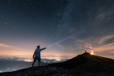 Italy, Monte Nerone, silhouette of a man with torch under night sky with stars and milky way - WPEF01324
