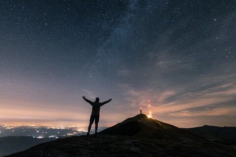 Italy, Monte Nerone, silhouette of a man looking at night sky with stars and milky way stock photo