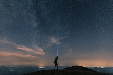 Italy, Monte Nerone, silhouette of a man with torch under night sky with stars and milky way - WPEF01327