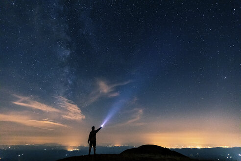 Italien, Monte Nerone, Silhouette eines Mannes mit Fackel unter Nachthimmel mit Sternen und Milchstraße - WPEF01328