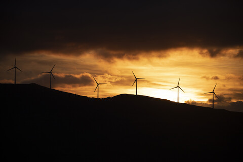 Spanien, Andalusien, Tarifa, Windräder auf Berg bei Sonnenaufgang, lizenzfreies Stockfoto