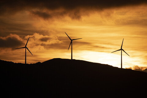 Spanien, Andalusien, Tarifa, Windräder auf Berg bei Sonnenaufgang, lizenzfreies Stockfoto