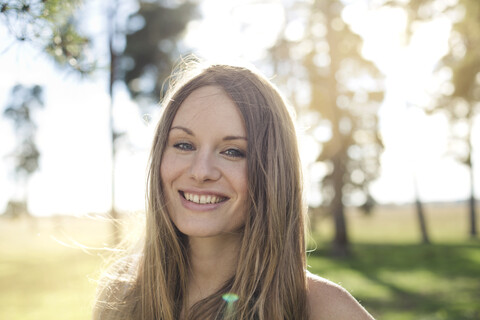 Porträt einer lächelnden jungen Frau in der Natur, lizenzfreies Stockfoto