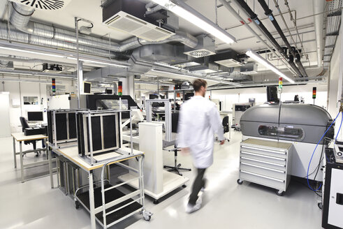 Man walking in a factory for manufacturing of circuit boards for the electronics industry - LYF00903