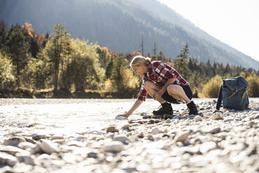 Austria, Alps, woman on a hiking trip having a break at a brook - UUF16507