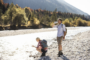 Österreich, Alpen, Wanderpärchen bei einer Pause an einem Bach - UUF16511