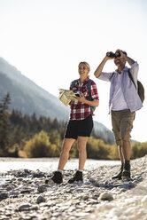 Austria, Alps, couple on a hiking trip with map and binoculars - UUF16532