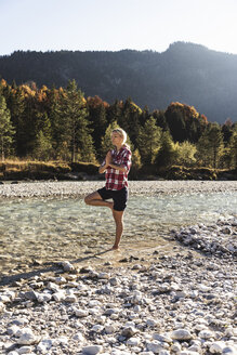 Österreich, Alpen, Frau übt Yoga in einem Gebirgsbach - UUF16547