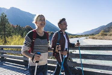 Austria, Alps, happy couple on a hiking trip crossing a bridge - UUF16555