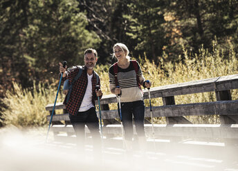 Austria, Alps, Couple crossing bridge walking with hiking poles - UUF16558