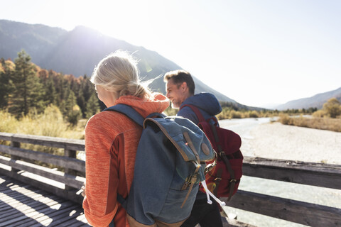 Austria, Alps, couple on a hiking trip crossing a bridge stock photo