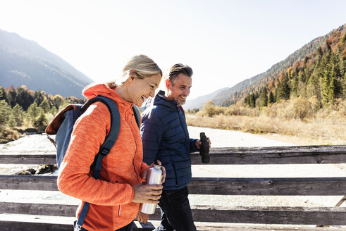 Austria, Alps, happy couple on a hiking trip crossing a bridge - UUF16582