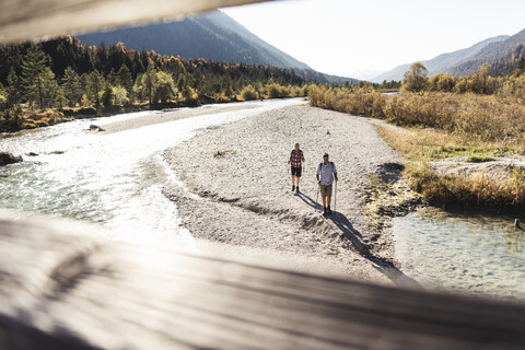 Austria, Alps, couple on a hiking trip walking along a brook stock photo