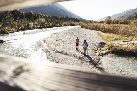 Österreich, Alpen, Paar beim Wandern entlang eines Baches, lizenzfreies Stockfoto