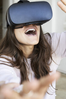 Young woman having fun using virtual reality headsets at home - IGGF00739
