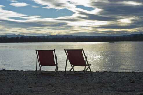 Deutschland, zwei leere Liegestühle am Ufer des Ammersees bei Sonnenuntergang - CRF02822