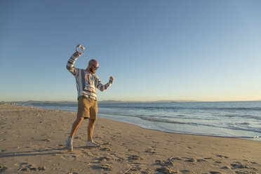 Man with headphones and sunglasses at the beach - KBF00468