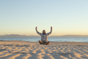 Man with headphones and sunglasses sitting on the beach - KBF00473