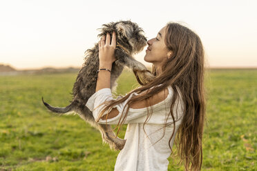 Smiling girl cuddling dog outdoors - ERRF00684